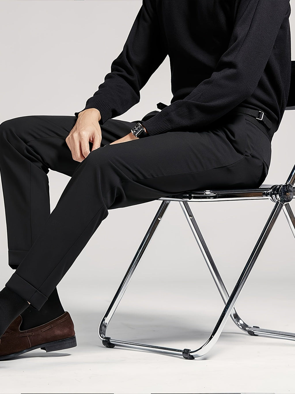 Men's black tailored pleated high-waist trousers, seated view
