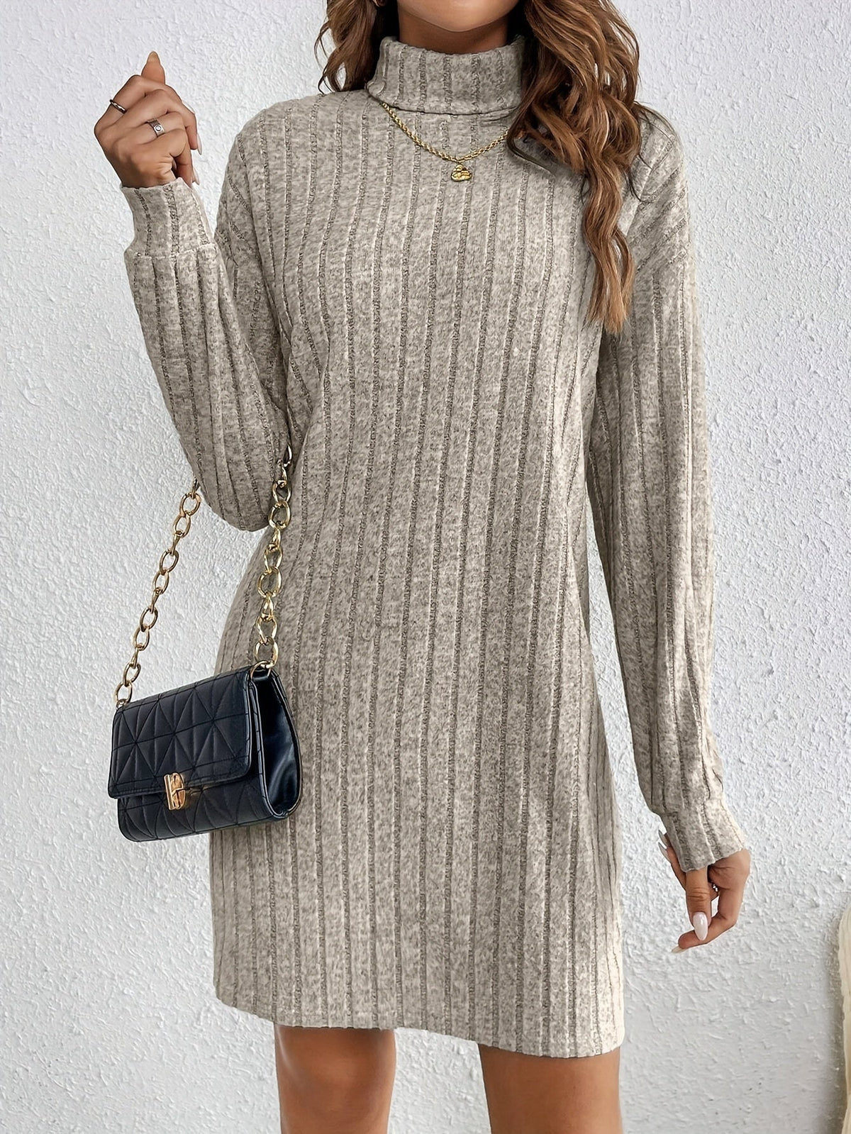 Women's khaki ribbed turtleneck sweater dress styled with a handbag