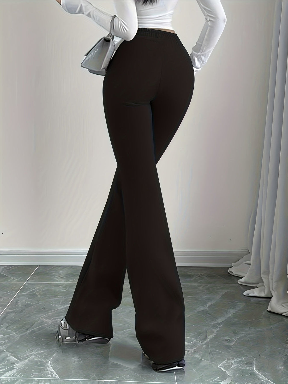 Women's black high-waisted flared lounge pants, side profile view