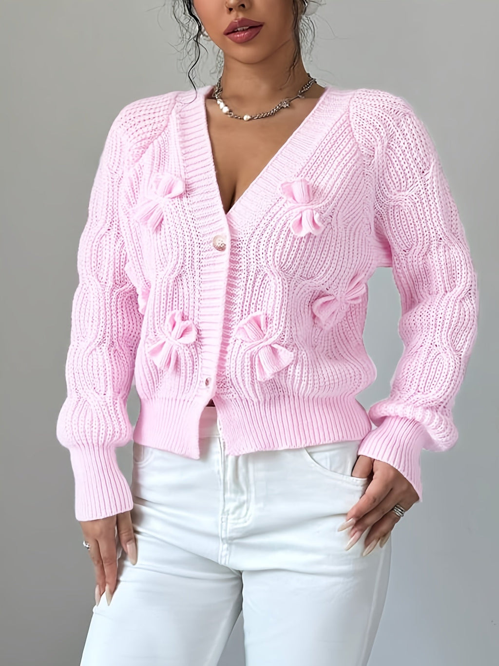 Women's pink knit cardigan with delicate bow details