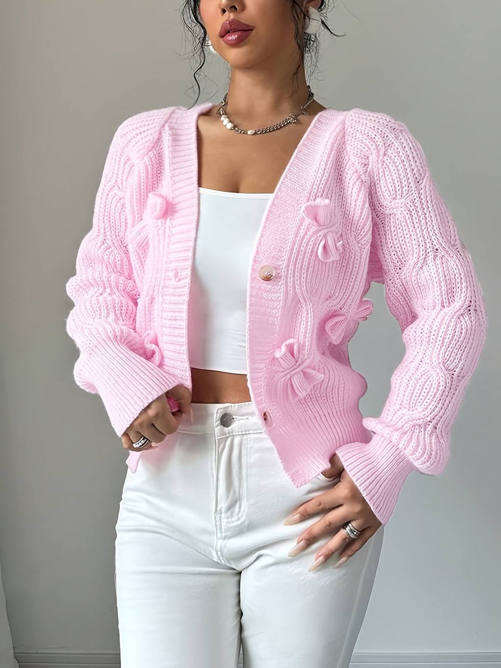 Women's pink bow-detail cardigan with a button-front closure